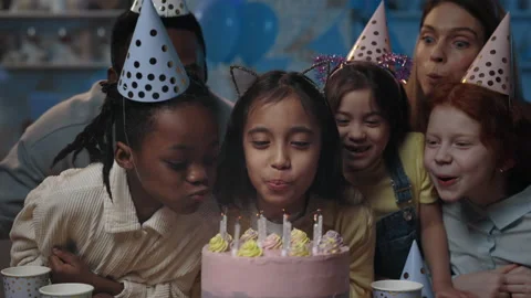 Crop view of multi ethnic children and adults blowing candles on cake all Stock Footage 152531420