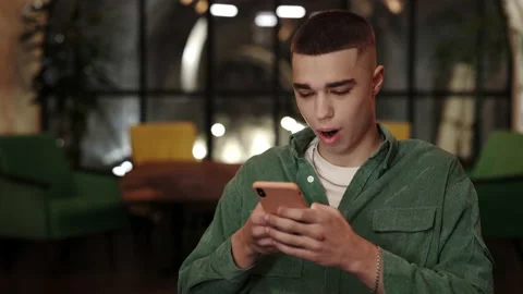 Crop view of stylish man looking amazed and saying wow while using smartphone in Stock Footage 152351072