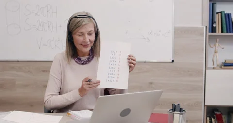 Crop view of teacher talking and showing multiplication table while looking at Stock Footage 147928399