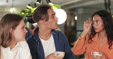 Crop view of young colleagues drinking coffee and talking while having break Stock-Footage 135590709