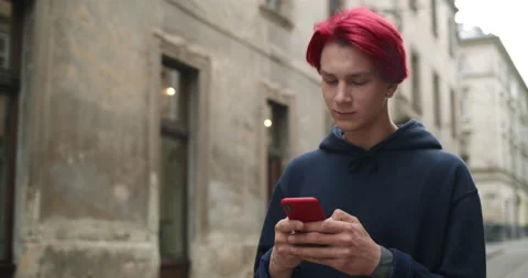 Crop view of young man with earring typing message and looking at phone screen Stock Footage 143142979