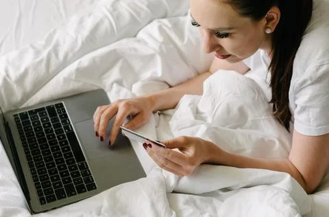 Crop woman using tablet while shopping on bed Stock Photos