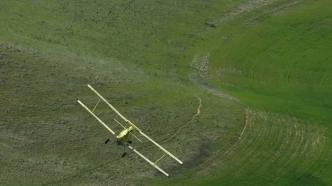 A Cropduster or Crop Duster Spraying a Field Stock Footage 75335456