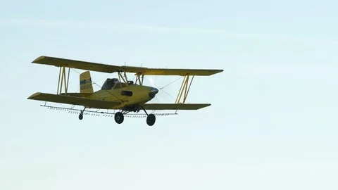 A Cropduster or Crop Duster Spraying a Field Stock Footage 78204526