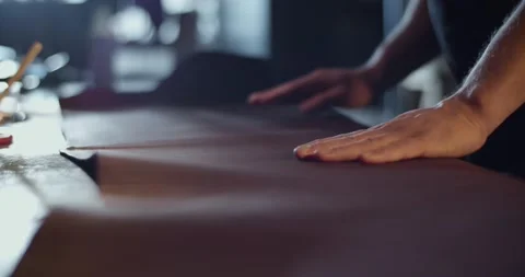 Cropped artisan spreading leather on table Stock Footage 172488141