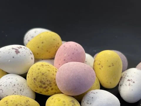 Cropped close up of chocolate easter eggs candy on black background Stock Photos