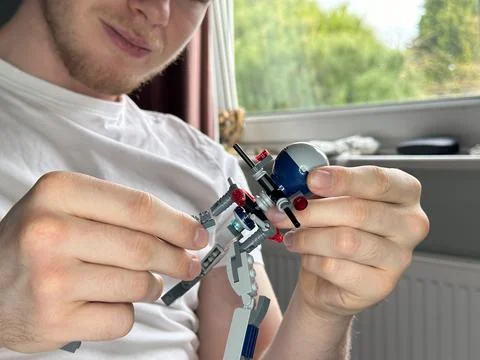 Cropped close up of constructor toy in the hands of a bearded man Stock Photos