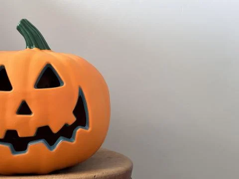 Cropped close up of a jack-o-lantern halloween pumpkin against grey backgroun Stock Photos