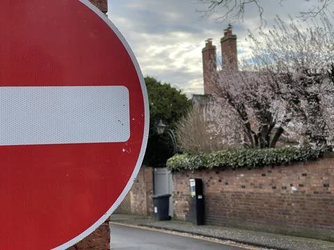 Cropped close up of red no entry for vehicular traffic sign, cozy brick house Stock Photos