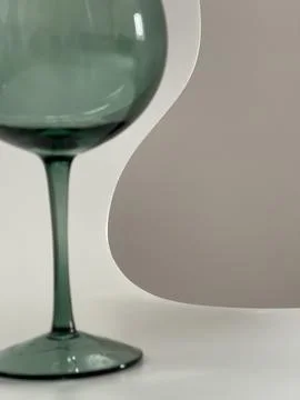 Cropped close up of smooth elegant lines of a green glass on white background Stock Photos