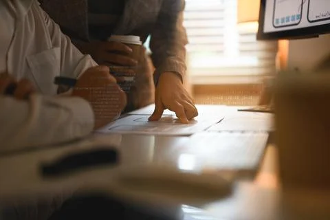 Cropped developer team brainstorming and discussing new app features at co Stock Photos