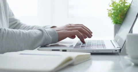 Cropped female hands write in a notebook and work on a laptop.  Stock Footage 151746449