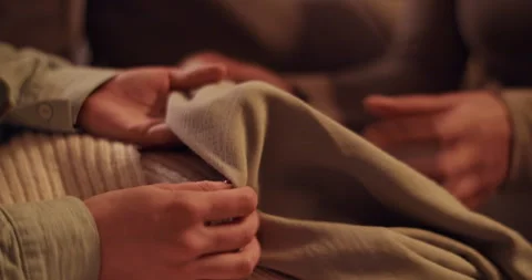 Cropped girlfriends combining clothes on sofa Stock Footage 259716299