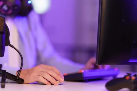 Cropped hand holding computer mouse on desk for gaming livestream and podcasting 写真素材
