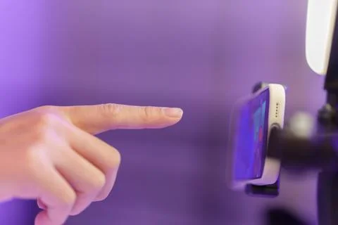 Cropped hand pointing finger to touch screen on mounted smartphone Stock Photos