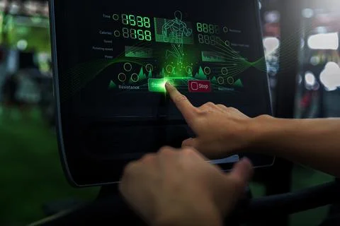 Cropped hand pressing start button on treadmill console for fitness workout Stock-Fotos