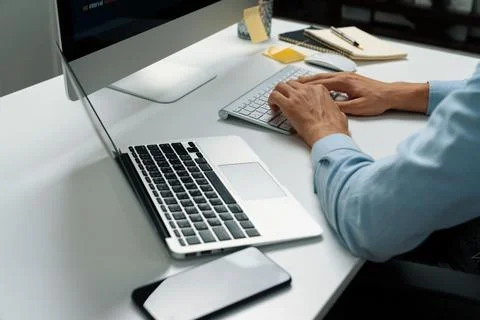 Cropped hands IT developer working online software information on pc. Pecuniary. Foto stock