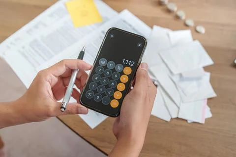 Cropped hands using calculator app on smartphone for tax planning Stock Photos