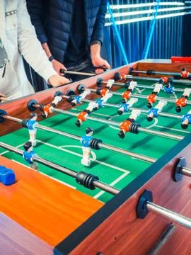 Cropped image of active people playing foosball. table soccer plaers. Friends Foto stock