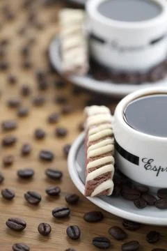 Cropped image of coffee cups with beans and cookie chips Stock Photos