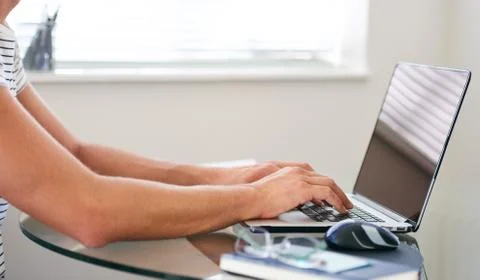 Cropped image of composed man's hands typing on a laptop Foto stock
