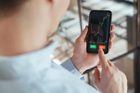 Cropped image of crypto trader going to press sell button under scale of chart Stock Photos