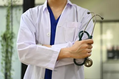 Cropped image of general practitioner in white coat with stethoscope standing at Stock Photos