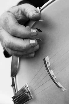 Cropped image of hand playing string instrument against gray background Stock Photos