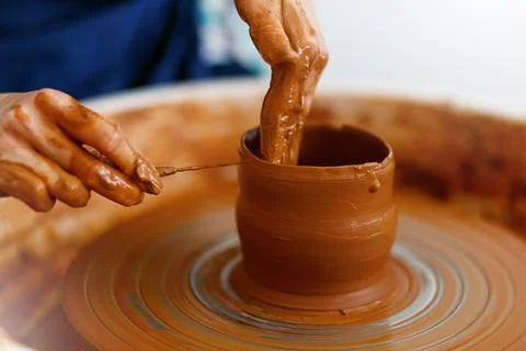 Cropped Image of hands working with Pottery Wheel, close up of shaping clay Stock Photos