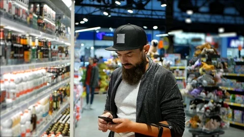 Cropped image of handsome man using a smart phone and smiling while doing Video stock 98944130