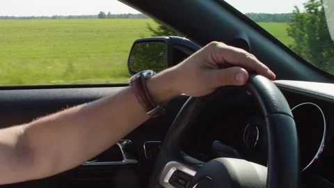 Cropped image of man driving car with landscape in background Stock Footage 247692896