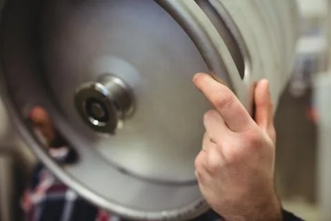 Cropped image of manufacturer holding keg in brewery Stock Photos