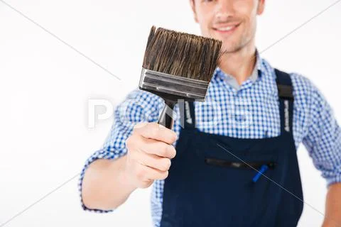 Cropped image of smiling male builder holding paint brush Stock Photos