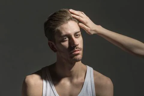 Cropped image of woman's hand touching boyfriend against gray background Stock Photos