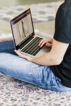 Cropped image of a young man working on computer sitting at wooden table Stock Photos