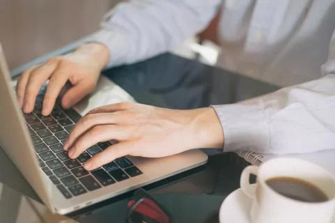 Cropped image of a young man working on his laptop, man hands busy using lapt Stock Photos