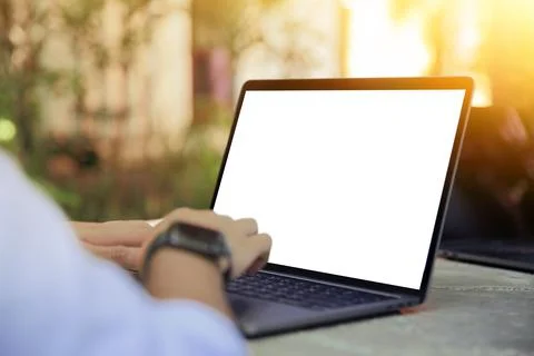 Cropped image of a young man working on his laptop in a garden, rear view of  Stock Photos