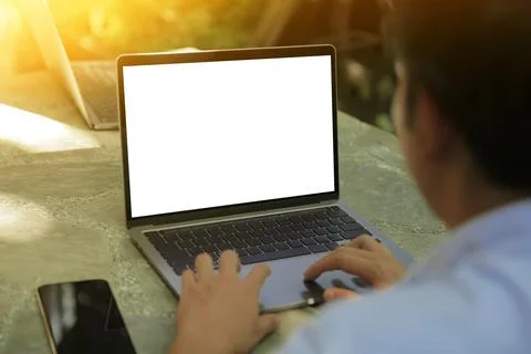 Cropped image of a young man working on his laptop in a garden, rear view of  Stock Photos