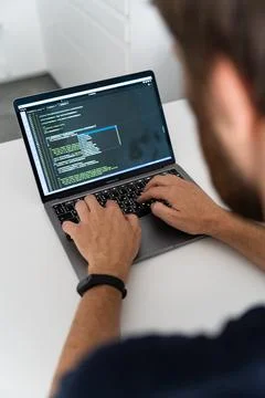 A cropped image of a young man working on a computer. Stock Photos