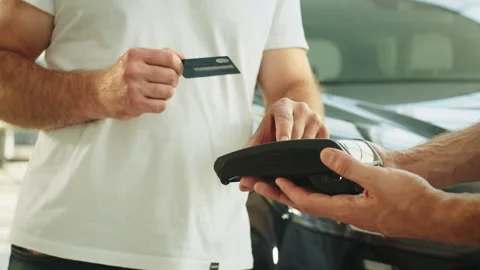 Cropped man customer buyer client male hand hold wireless bank payment terminal Stock Footage 240551616