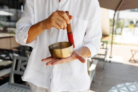 Cropped man hands using singing bowl in sound healing therapy outdoors, closeup Stock Photos