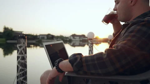 Cropped portrait of a young man using a laptop at sunset Stock Footage 203793142