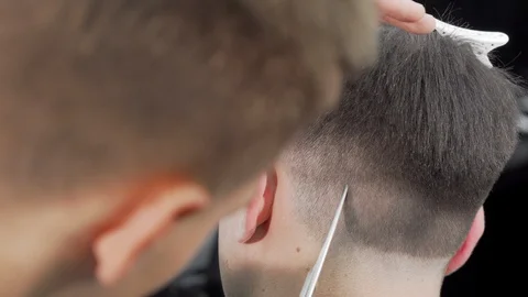 Cropped rear view shot of a barber cutting hair of a male client Stock-Footage 116972973