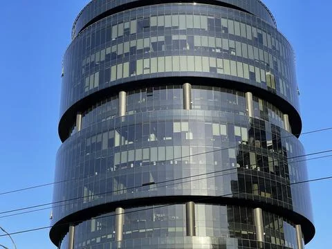Cropped shot of a beautiful round black glass skyscraper in sunlight Stock Photos