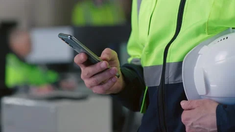 Cropped shot of builder chat on smartphone holding hardhat Stock Footage 197564226