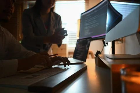 Cropped shot of developers brainstorming, programming code on computer screen at Stock Photos