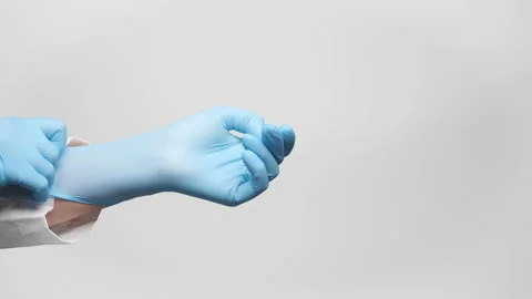 Cropped shot of a doctor pulling up blue medical gloves, close up. 4k, slow m Video stock 238554411