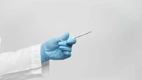 Cropped shot of a doctor's hand in a blue glove holding scissors for manicure Stock Footage 238611038