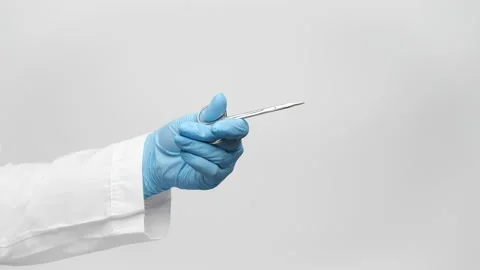 Cropped shot of a doctor's hand in a blue glove holding scissors for manicure Stock Footage 238611193