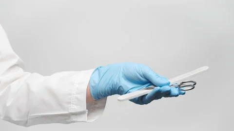 Cropped shot of a doctor's hand in a blue glove holding scissors for manicure Video stock 238611196